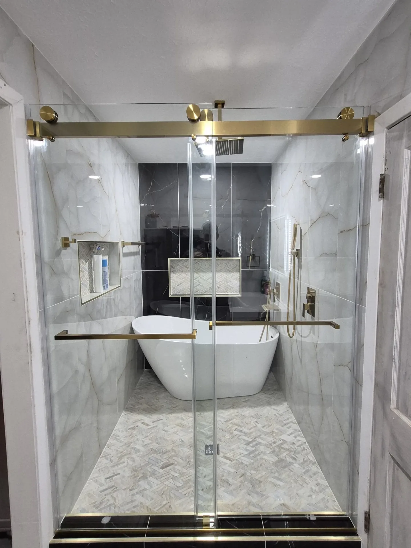 Bathroom remodel by LL General Contractor with a freestanding tub in a marble alcove