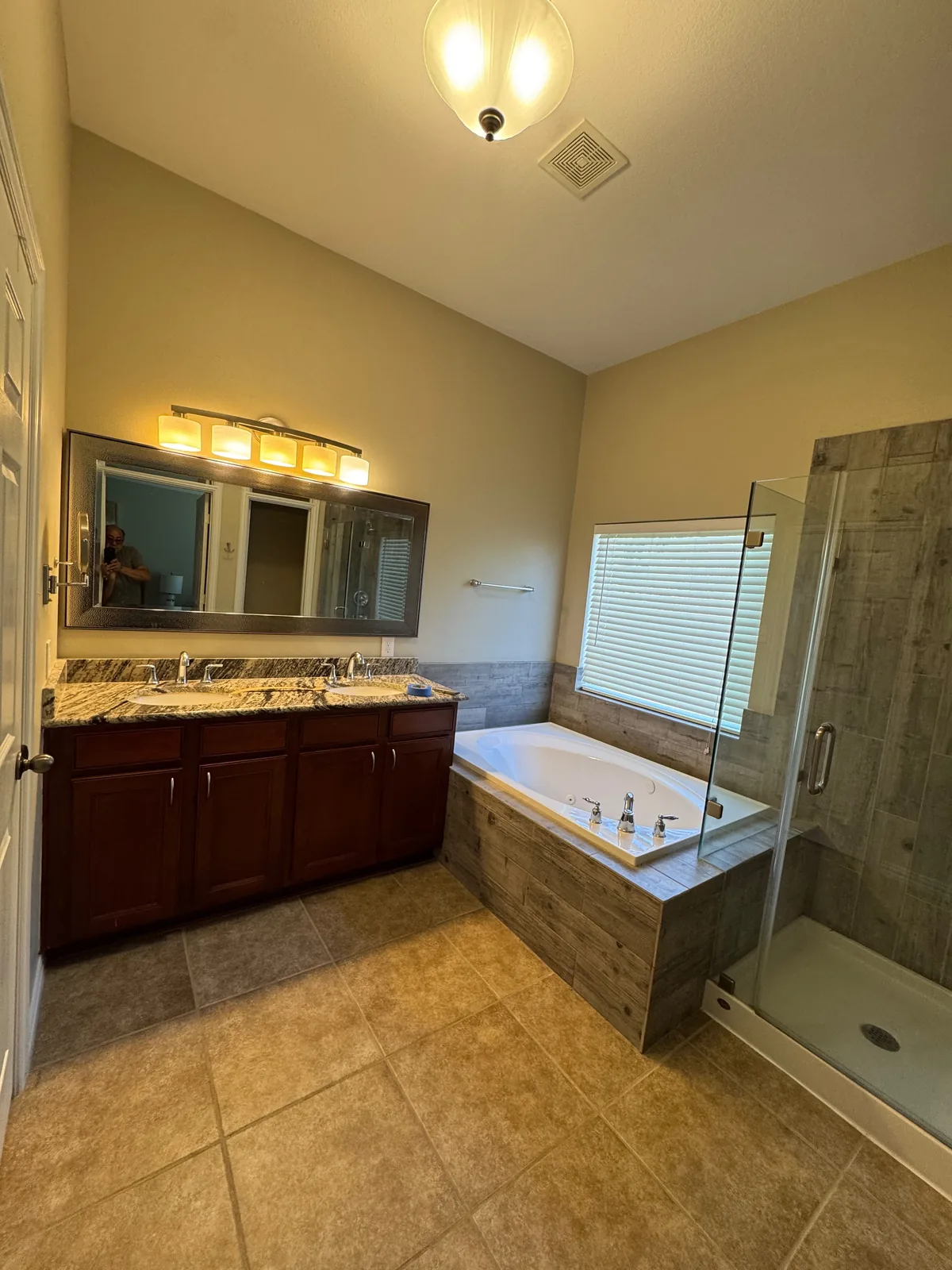 A Houston master bathroom refreshed with a teal vanity, round mirrors and a walk in shower before the remodel