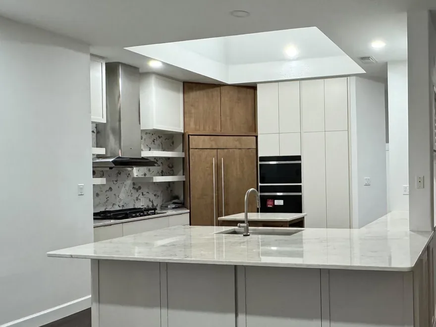 A Houston kitchen rebuilt with a quartz island and new hardwood floors after the remodel