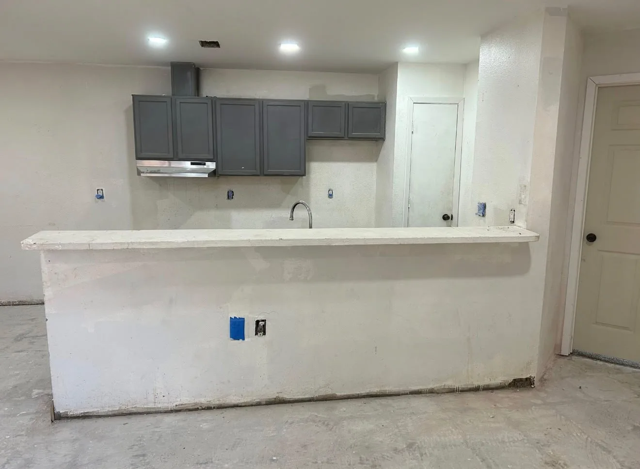 A Houston kitchen rebuilt with blue gray cabinets, granite counters and a subway tile backsplash before the remodel
