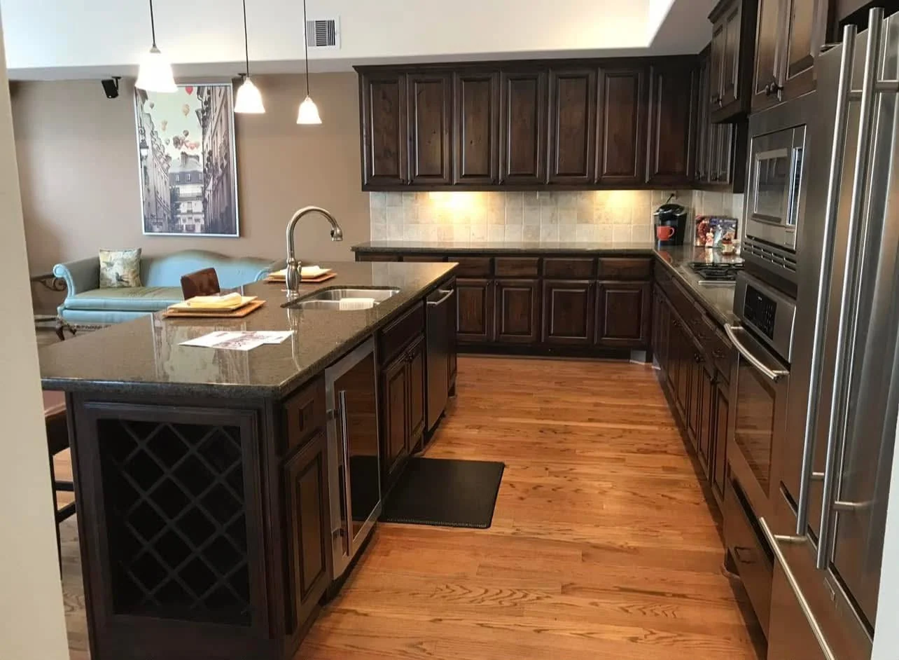 Kitchen with custom dark wood cabinetry and hardwood floors by LL General Contractor