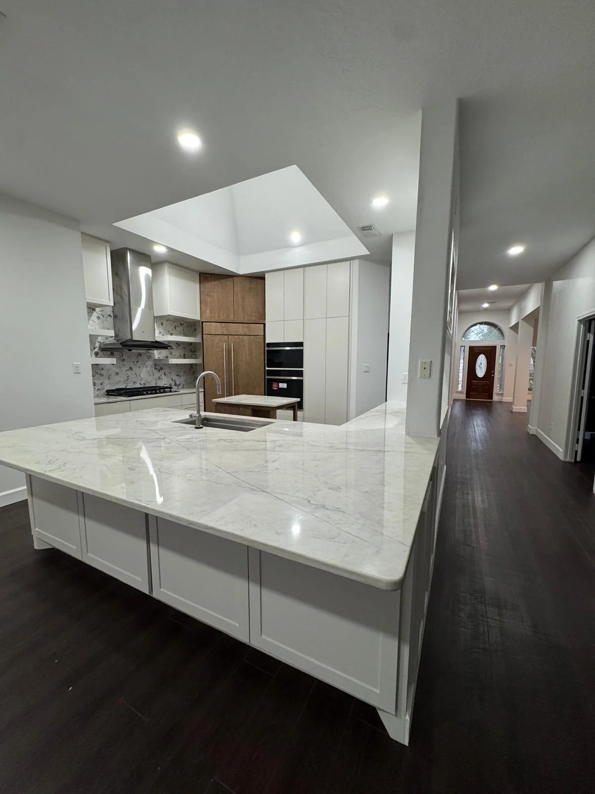 Kitchen remodel by LL General Contractor with a marble waterfall island